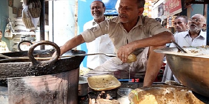 A man who specializes fritters frying in boiling oil