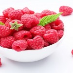 Crockery with  beautiful tempting raspberries Isolated on white background.