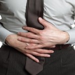 Businessman holding his stomach in pain or indigestion
