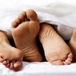 Close-up of the feet of a couple on the bed