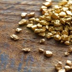 a mound of gold on a old wooden work table