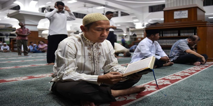 A man reads the koran as Indonesian Muslims wait for the first day of Ramadan prayers at Al-azhar Mosque in Jakarta on June 17, 2015, to mark the Muslim holy fasting month. More than 1.5 billion Muslims around the world will mark the month, during which believers abstain from eating, drinking, smoking and having sex from dawn until sunset. AFP PHOTO / Bay ISMOYO (Photo credit should read BAY ISMOYO/AFP/Getty Images)