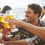 Three Male Friends Enjoying Drink At Outdoor Rooftop Bar