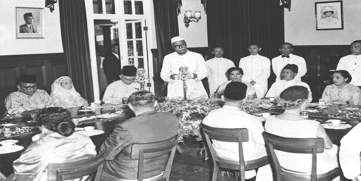 E.A. Ministry/December, 1958, 5 The President of India Dr. Rajendra Prasad arrived in Kuala Lampur on December 6, 1958 on a three-day Date visit to Malaya. Photo shows the President of India proposing the toast to the health of His Majesty the Yang Di-Partuan Agong, the Government and the people of the Federation of Malaya at a Royal Banquet held in his honour at Kuala Lumpur on December 6. On the extreme right is Her Majesty the Raja Permaisuri Agong, and on the extreme left. Her Highness the Tengku Ampuan of Selangor.